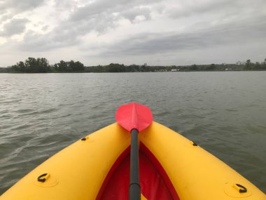 Kırmızı kürek sarı kanoyla nehirde