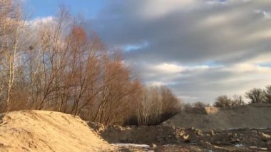 Kümülüs bulutları donmuş bir gölün üzerinde kumlu kumsalda