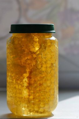 Yeşil kapaklı cam kavanozdaki bal.
