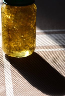 Yeşil kapaklı cam kavanozdaki bal.