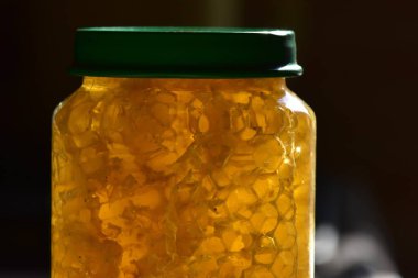 Yeşil kapaklı cam kavanozdaki bal.