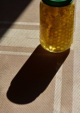 Yeşil kapaklı cam kavanozdaki bal.