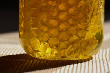 Yeşil kapaklı cam kavanozdaki bal.