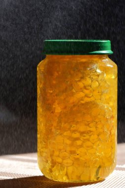 Yeşil kapaklı cam kavanozdaki bal.