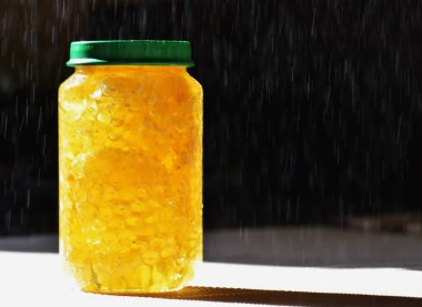 Yeşil kapaklı cam kavanozdaki bal.