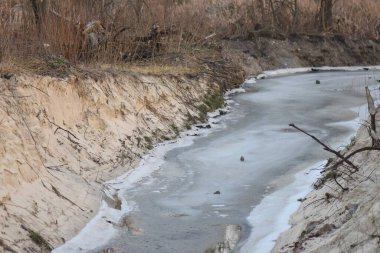 Kışın kumlu sahilde buz ve kar, fotoğrafın yakın çekimi.