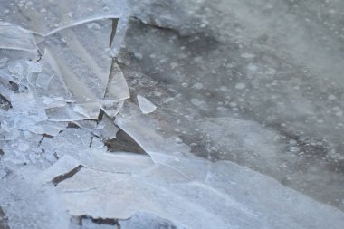 Kışın kumlu sahilde buz ve kar, fotoğrafın yakın çekimi.