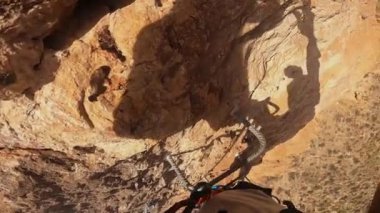 Bir karabinayı ferrata ile metal kabloya bağlayan bir dağcının bakış açısı. Dağcılar için güvenlik yöntemi, yavaş çekim.