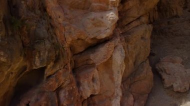 Ferrata ile. Bir adam ferrata ve kireçtaşı duvarlarıyla dağa tırmanıyor. Dağcı tırmanırken keşfedilene kadar yolun merdivenlerini görürüz..