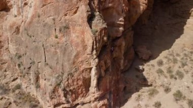 Ferrata ile. Sıcak renkli bir dağın, güvenlik ekipmanları, miğferi, koşum takımı ve ısıtıcısı, insansız hava aracı görüntüsü, dairesel hareket.