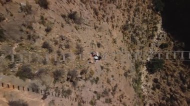 Kişisel gelişim, bir adam asma köprüden geçer, kuş bakışı, tırmanma ekipmanları ile donatılmış..