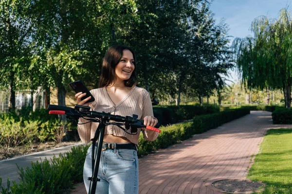 Scooter Eléctrico Dispositivo Móvil Chica Sonriente Utiliza Móvil Mientras Camina — Foto de Stock