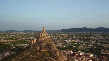 İsa 'nın heykelinin dairesel hava görüntüsü. Cristo de Monteagudo, Murcia, İspanya. Gün batımında hava videosu