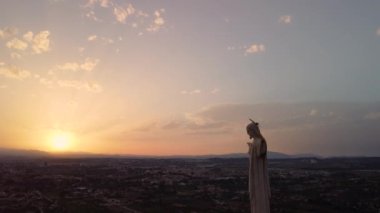 Gün batımında güneşe bakan İsa heykeli. Cristo de Monteagudo, Murcia, İspanya. hava videosu.