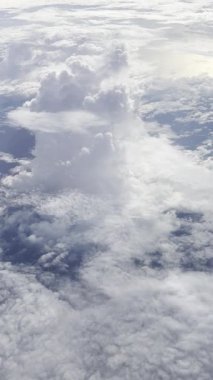 Uçak penceresinden dikey görüntü, uçaktan güzel bulutlar. Seyahat ve tatil kavramı.