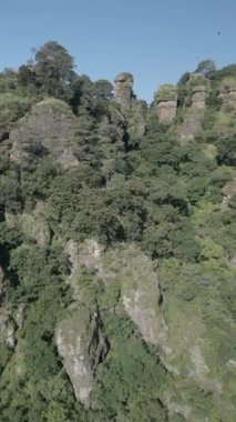 Dikey İHA videosu. Kaya oluşumları, orman dağları ve büyük oluşumlar. Yeşil ormanda yürüyüş yapmak. Yürüyüş konsepti. Amatlan, Meksika