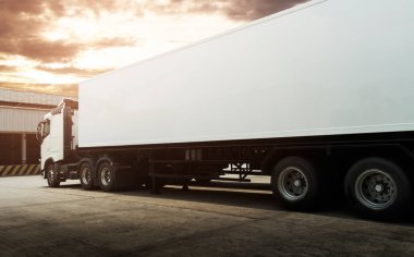 Semi TrailerTrucks Sunset Sky ile park yerinde. Nakliye konteynırı. Teslimat Transit. Motor Diesel Trucks. Kamyon Traktörü. Endüstriyel Yük Kamyonları Lojistik Taşımacılık.