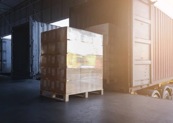 Packaging Boxes Wrapped Plastic Stacked on Pallets Loading into Cargo Trucks. Shipping Trucks. Supply Chain Shipment Boxes. Distribution Supplies Warehouse. Freight Truck Transport Logistics.