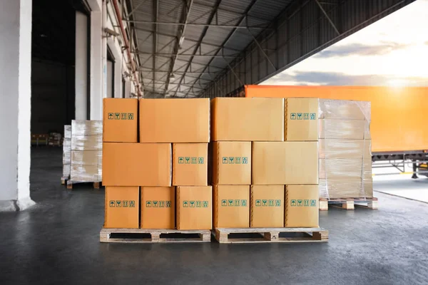 Packaging Boxes Stacked on Pallets Loading into Cargo Container. Cartons, Cardboard Boxes. Distribution Supplies Warehouse. Shipping Trucks. Supply Chain Shipment Boxes. Freight Truck Logistics.