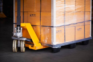 Paletleri Paketlenmiş Plastik Kutuları olan El Paleti Kamyonu. El kaldırma, Palet Kutuları, Karton Kutular. Malzemeler. Kargo Malzemeleri Depo Lojistiği.