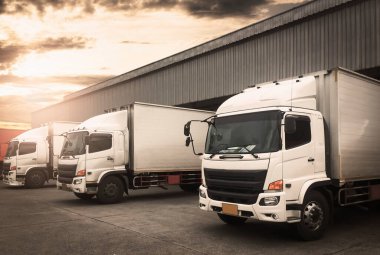 Kargo konteynırı kamyonları rıhtım deposuna park etmiş. Kargo konteynırı nakliye kamyonları. Dağıtım Deposu. Yük Kamyonları Kargo Taşımacılığı. Depo Lojistiği.