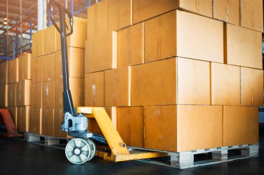 Paletler Yığılmış Paket Kutuları ile El Paleti Kamyonu. El kaldırma, Palet Jack Yükleyici. Tedarik zinciri malları. Depo Dağıtımı. Kargo Nakliyat Deposu Lojistik Malzemeleri