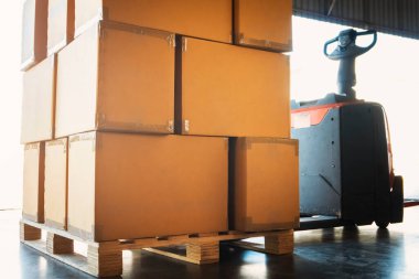 Elektronik Forklift Yükleyicisiyle Palet 'in üzerine istiflenmiş paketleme kutuları. Kutular, karton kutular. Malzemeler. Malzeme Deposu Lojistiği.