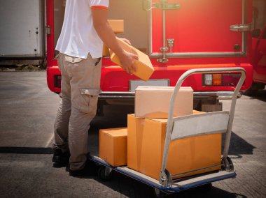 Teslimatçı, The Cart 'ın üstündeki paket kutusunu kaldırıyor. İşçi Kuryesi. Teslimat kamyonları. Müşterilere Sevkiyat.