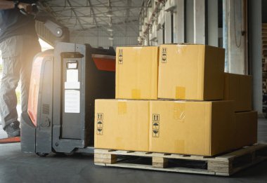  Depo 'da elektrikli forklift paleti olan paket kutuları. Forklift Yükleyici. Nakliye malzemeleri. Tedarik Zinciri Nakliye Malzemeleri. Dağıtım Deposu Lojistiği
