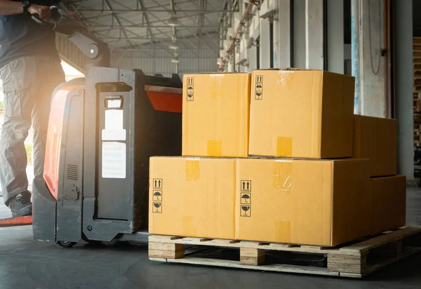 Package Boxes with Electric Forklift Pallet Jack in Warehouse. Forklift Loader. Shipping Supplies. Supply Chain Shipment Goods. Distribution Warehouse Logistics