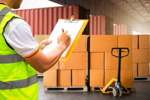 作業者は 配布倉庫のロードパッケージボックスを確認するクリップボードを保持します お客様への配送 貨物トラック 倉庫物流輸送 — ストック写真