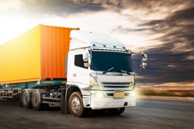 Yarı karavan kamyonu gün batımıyla birlikte yolda gidiyor. Kamyon farlarını yak. Ticari Kamyon, Ekspres Teslimat Transit. Nakliye konteynırı. Nakliye Aracı Lojistik, Kargo Taşımacılığı.