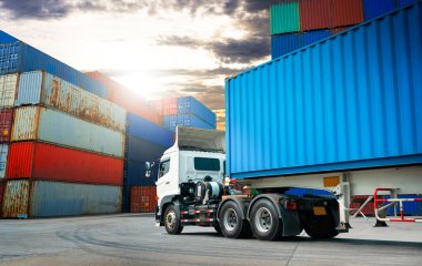 Deponun otoparkındaki yarı karavan kamyonları. Rıhtım deposunda kamyonlar yükleniyor. Kargo konteynırı nakliye kamyonları. Dağıtım Deposu. Nakliye Aracı Lojistik, Kargo Taşımacılığı.
