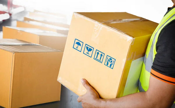 Worker Holding A Parcel Boxes. Package Boxes Sorting on Conveyor Belt. Cartons, Cardboard Boxes. Delivery to Customers. Storehouse. Distribution Warehouse Shipping. Supplies Shipment.