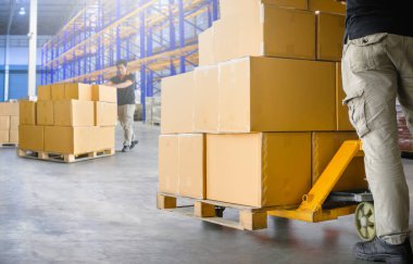 İşçiler, Depo 'daki paketlerin üzerine paket kutularını boşaltıyorlar. Kutular, karton kutular. Depo, Dağıtım, Tedarik Zinciri. Depo Nakliyat Malzemeleri.