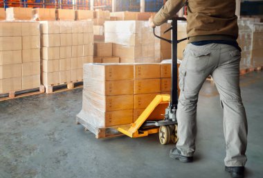 İşçiler ambalaj kutularını boşaltıyorlar ambalajlı plastikleri depodaki paletlere. Karton Kutular, Paketler, Depo Nakliyesi, Tedarik Zinciri Dağıtım Deposu, Malzeme Nakliye Kutuları. Lojistik