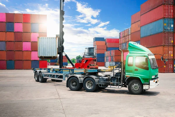 Container Crane Tractor Lifting up Container Box on Trailer Truck. Handling of Logistics Transportation Industry. Cargo Container ships, Freight Trucks Import-Export. Distribution Warehouse Shipping.