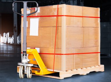 Paket Kutuları Palet ve El Paleti Kamyonu 'na Paketlenmiş Plastik. Forklift Yükleyici. Depo deposu. Tedarik Zinciri Malzemeleri Sevkiyatı. Dağıtım Deposu Lojistiği
