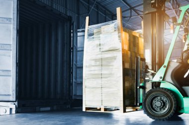 Forklift Traktör Kutuları konteyner kamyonuna yükleniyor. Forklift Palet Kamyonu, Yükleyici. Teslimat Kargosu Müşterilere Gönderiliyor. Sevkiyat Malzemeleri Deposu Nakliyat. Nakliye Aracı Lojistik