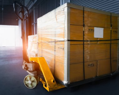 Paletler ve El Paleti Kamyonu 'na istiflenmiş paket kutuları. Kutular, karton kutular. Depo, Dağıtım, Tedarik Zinciri. Depo Nakliyat Malzemeleri.