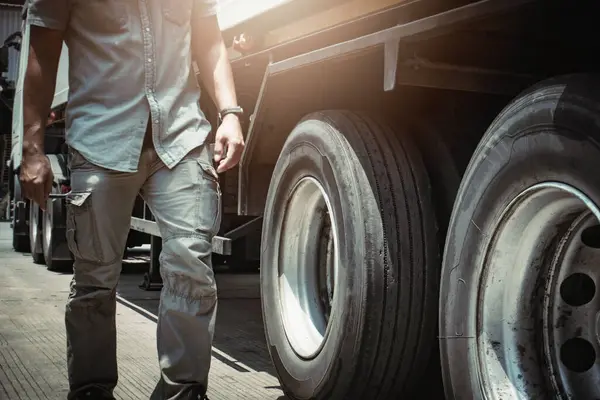 Conductor Del Camión Está Comprobando Seguridad Los Neumáticos Las Ruedas Imagen de stock