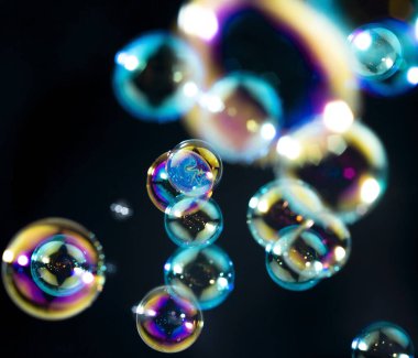 Havada yüzen saydam renkli sabun köpükleri. Soyut arkaplan. Sabun köpüklü su Siyah üzerine su.