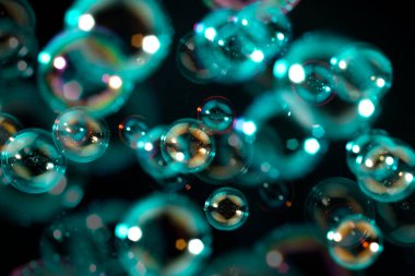 Havada yüzen saydam renkli sabun köpükleri. Soyut arkaplan. Sabun köpüklü su Siyah üzerine su.