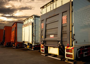Dağıtım deposundaki otoparktaki konteynır kamyonları. Rampa Kamyonu kaldırılıyor. - Lorry. Nakliye kamyonları. Nakliye Aracı Lojistik Kargo Taşımacılığı