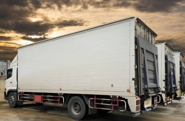 Dağıtım deposundaki otoparktaki konteynır kamyonları. Rampa Kamyonu kaldırılıyor. - Lorry. Nakliye kamyonları. Nakliye Aracı Lojistik Kargo Taşımacılığı