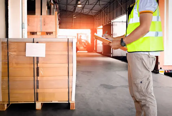 Worker Holds Clipboard Checking Loading Cargo Shipment Distribution Warehouse Forklift Royaltyfria Stockfoton