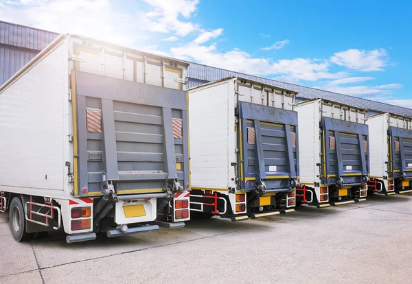 Deponun otoparkındaki konteynır kamyonları. Rampa kamyonlarını kaldırıyorum. Ticari Kamyon Nakliye Lorry. Nakliye kamyonları. Dağıtım Deposu. Nakliye Aracı Lojistik Kargo Taşımacılığı