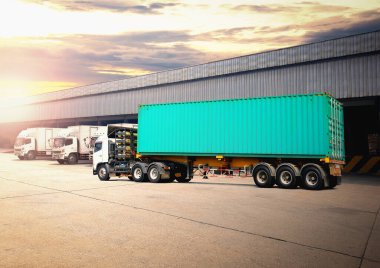 Deponun otoparkındaki yarı karavan kamyonları. Rıhtım deposunda kamyonlar yükleniyor. Kargo konteynırı nakliye kamyonları. Dağıtım Deposu. Yük Kamyonları Lojistik, Kargo Taşımacılığı.