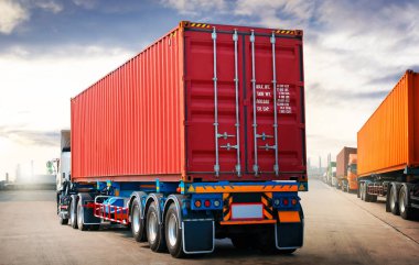Park alanındaki yarı karavan kamyonları ve Sunset Sky. Kargo konteynırı nakliyesi. Ekonomi sektörü taşımacılığı. Kamyonculuk. Lorry Diesel Trucks. Nakliye Aracı Lojistik Taşımacılığı.