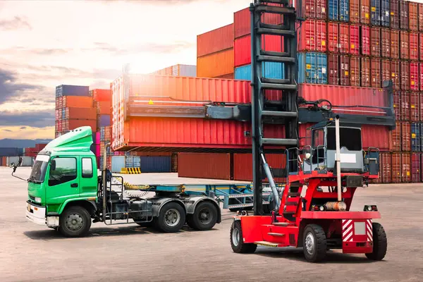 Konteyner Crane Traktörü, konteyner kutusunu karavan kamyonuyla kaldırıyor. Lojistik Taşımacılık Endüstrisi 'nin idaresi. Kargo konteynırı gemileri, nakliye kamyonları ithalat-ihracat. Dağıtım Deposu Nakliyat.